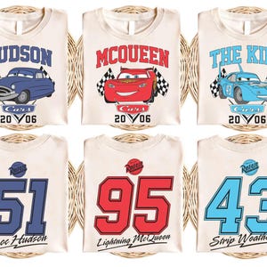 Pu&ograve; includere: Tre magliette bianche con personaggi di Cars e numeri di gara. La prima maglietta presenta Doc Hudson, un'auto blu con il numero 51. La seconda maglietta presenta Saetta McQueen, un'auto rossa con il numero 95. La terza maglietta presenta Saetta McQueen, un'auto blu con il numero 43.