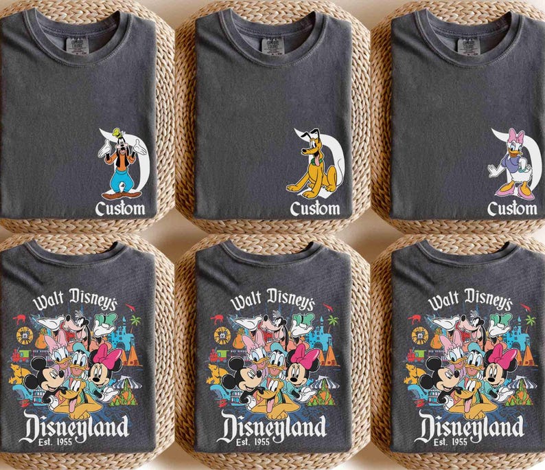 以下が含まれることがあります： 異なるデザインのグレーのTシャツ6枚。最初の3枚のシャツは、プルート、グーフィー、デイジー・ダックなど、ディズニーの漫画のキャラクターが描かれています。最後の3枚のシャツは、ミッキーマウス、ミニーマウス、ドナルドダック、グーフィーなど、ディズニーのキャラクターのグループが描かれています。シャツにはすべて、「Walt Disney's Disneyland Est. 1955」という文字が印刷されています。