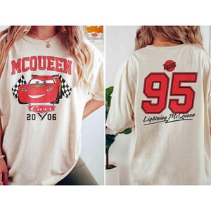 Pu&ograve; includere: Una maglietta bianca con una stampa Cars rossa e nera sul davanti. La stampa presenta Saetta McQueen, il numero 95 e il testo "McQueen" e "Cars 20 06". Il retro della maglietta ha un numero 95 rosso con il testo "Rust-eze" e "Lightning McQueen".
