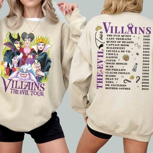 Pu&ograve; includere: Una felpa beige con una stampa grafica di cattivi Disney sul davanti e un elenco di cattivi Disney e le loro date di uscita dei film sul retro. Il testo sul retro recita "Villains The Evil Tour".