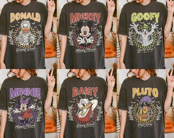 Könnte beinhalten: Sechs verschiedene T-Shirts mit verschiedenen Disney-Charakteren, die in Halloween-Kostümen gekleidet sind. Die Shirts sind alle schwarz mit weißem Text und Grafiken. Die Charaktere sind Mickey Mouse, Minnie Mouse, Donald Duck, Daisy Duck, Goofy und Pluto.