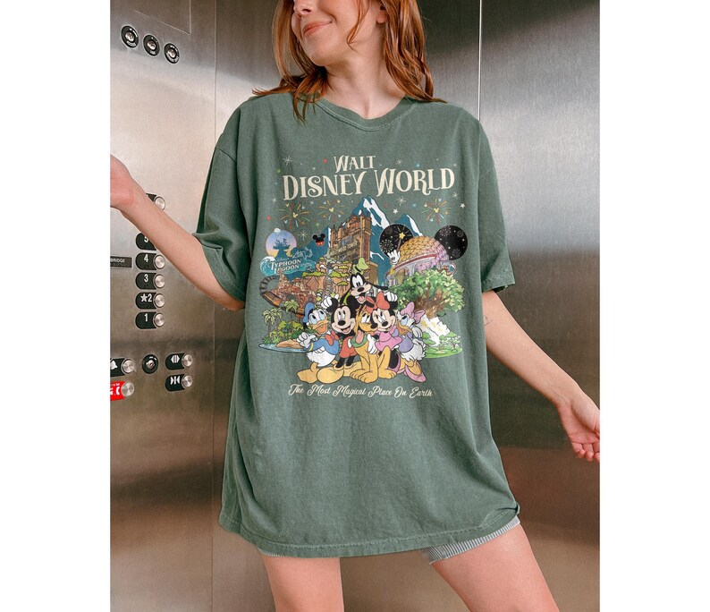 May include: Green t-shirt featuring a Disney World graphic with Mickey Mouse, Donald Duck, and other characters. The text "Walt Disney World" and "The Most Magical Place On Earth" are printed on the shirt, creating a nostalgic design.