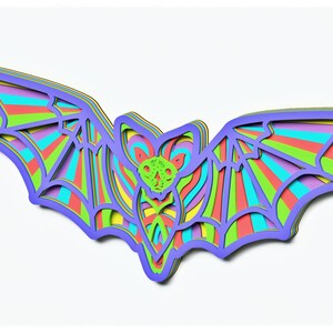 May include: A colourful layered paper bat with a rainbow striped design. The bat is cut out of paper and has a 3D effect.
