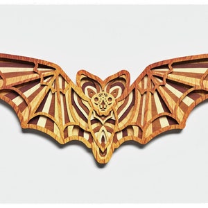 May include: A wooden bat cutout with a striped pattern in shades of brown and beige. The bat has a detailed face with intricate carvings.