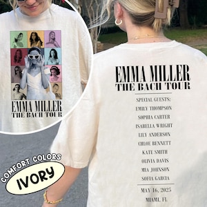 May include: Ivory-colored t-shirt featuring the text "EMMA MILLER THE BACH TOUR" on the front and back. The front design includes a collage of images. The back lists special guests, date, and location.
