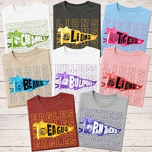 May include: A selection of crew neck t-shirts in different colours, each displaying a team name and mascot on a pennant design. The shirts feature the words "CARDINALS", "LIONS", "TIGERS", "BEARS", "BULLDOGS", "EAGLES", and "PANTHERS".