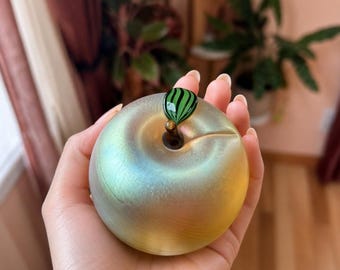 Beautiful signed art glass apple paperweight featuring soft iridescent finish in warm gold with green tones and a hand-applied leaf detail