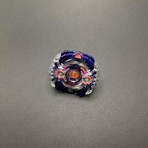 May include: A blue and red spinning top toy with a clear plastic frame and a silver metal center. The top has a star-shaped design on the center.