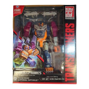 Könnte beinhalten: Eine Transformers Power of the Primes Optimal Optimus Actionfigur in der Originalverpackung. Die Box zeigt die Figur in Lila, Orange und Blau, inklusive zwei grauen Zubehörteilen. Die Verpackung ist mit dem Transformers-Logo versehen.