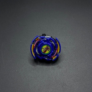 May include: Blue and yellow Beyblade with a red dragon design and the text "Dragoon S" on the side.