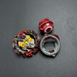 K&ouml;nnte beinhalten: Ein rotes, schwarzes und gelbes Beyblade mit einer silbernen und roten Performance-Spitze und einem roten Launch-Gear.