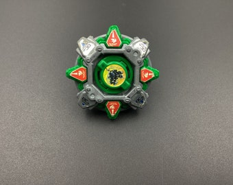 May include: A green and silver Beyblade with a black and yellow centre. The Beyblade has a red and white design on the outer ring.