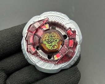 Könnte beinhalten: Ein silberner und roter Spielzeug-Kreisel mit einem braunen Mittelstück mit einem grünen Design. Der Kreisel hat eine kreisförmige Form mit roten, durchscheinenden Akzenten und einem metallisch-silbernen Außenring. Das Spielzeug ist zum Drehen und Spielen konzipiert.
