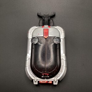 Könnte beinhalten: Eine silberne und schwarze Fernbedienung mit einem roten Knopf und der Aufschrift "RC".