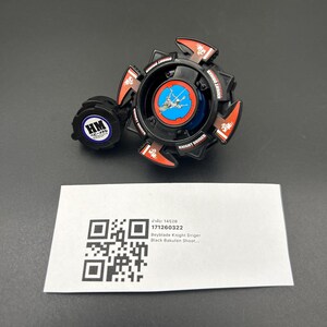 May include: A black and red Beyblade Knight Driger toy with a blue and white center design. The toy has a circular shape with red accents and the words "KNIGHT DRIGER" printed on it. A small, round, blue and white piece is attached to the side.