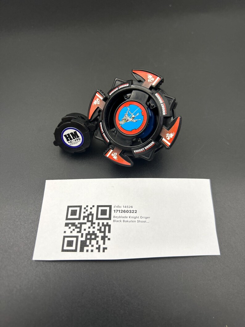 May include: A black and red Beyblade Knight Driger toy with a blue and white center design. The toy has a circular shape with red accents and the words "KNIGHT DRIGER" printed on it. A small, round, blue and white piece is attached to the side.