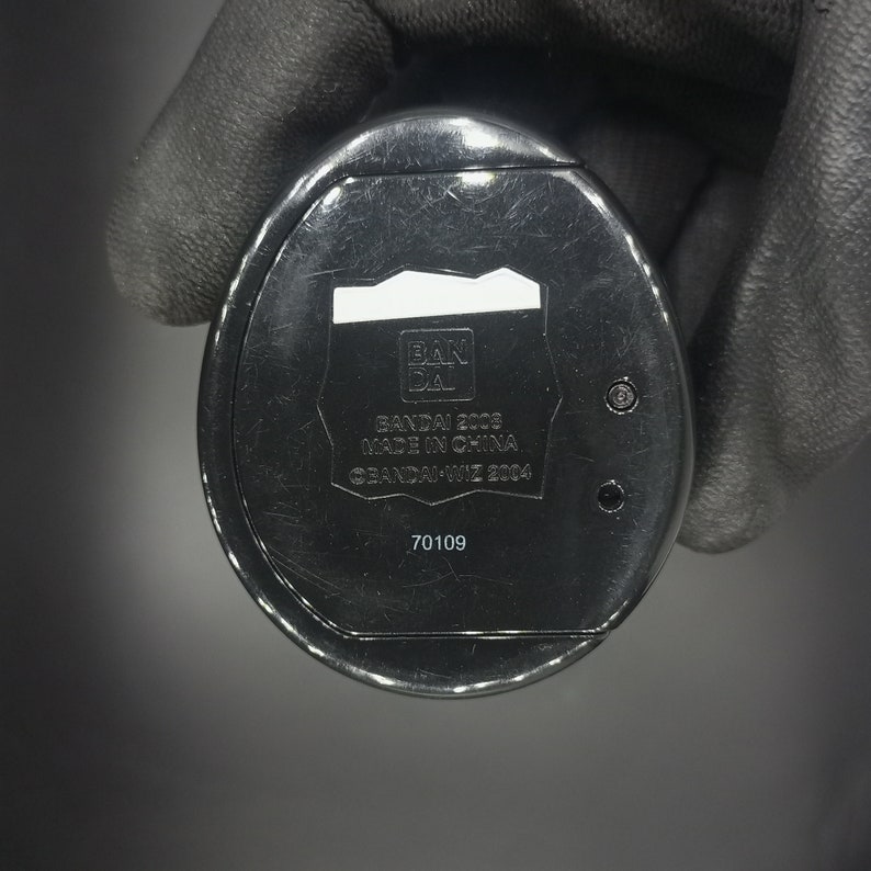 May include: Black plastic toy with the text "BANDAI 2003 MADE IN CHINA &copy;BANDAI-WIZ 2004" and the number "70109" printed on the bottom.