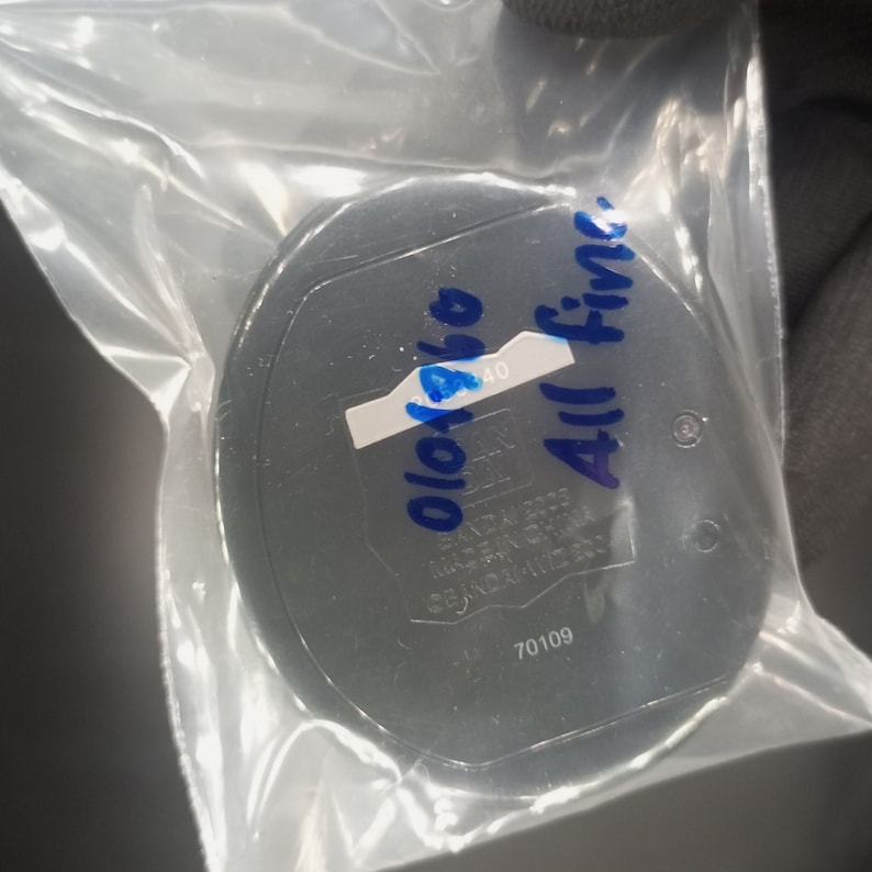 May include: A black round container with a white label that says "010140" and blue writing that says "All Fine". The container has a number "70109" printed on it.