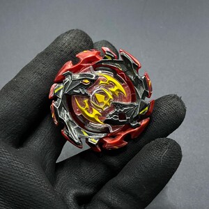 K&ouml;nnte beinhalten: Ein rotes und schwarzes Beyblade mit einem gelben und silbernen Design. Das Beyblade hat ein scharfes, kantiges Design mit einer durchsichtigen Plastikmitte.
