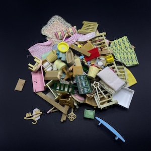 Könnte beinhalten: Eine Sammlung von Miniatur-Puppenhausmöbeln und -zubehör, darunter Betten, Stühle, Tische, Körbe und ein Schild mit der Aufschrift "Crab Oyster Fish". Die Artikel sind in verschiedenen Farben wie Rosa, Grün und Braun gehalten.