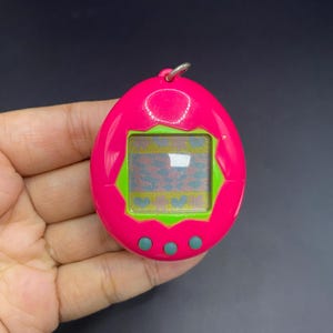 SKU B646P6716 TA8 | Original 1997 Bandai&#39;s Tamagotchi Virtual Reality Pet, Pink and Green
