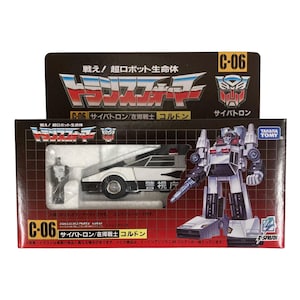 Può includere: Un set di action figure Transformers C-06 di Takara Tomy nella sua confezione originale. La scatola presenta un veicolo della polizia bianco e nero, una piccola figura e un'illustrazione di un robot su sfondo a griglia con testo giapponese.