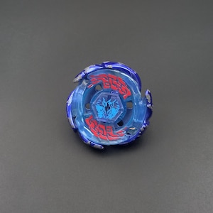 Pode incluir: Um brinquedo de pião azul e azul claro translúcido com um emblema hexagonal central apresentando um gráfico de cabeça de cavalo azul escuro. A estrutura circular tem detalhes decorativos vermelhos e pintura prateada metálica.