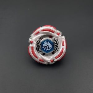Puede incluir: Un juguete de peonza circular con un marco en capas de color blanco y rojo con detalles en plata metálica. El centro contiene un emblema hexagonal azul con una ilustración gráfica blanca de una criatura tipo dragón y patrones tribales negros.