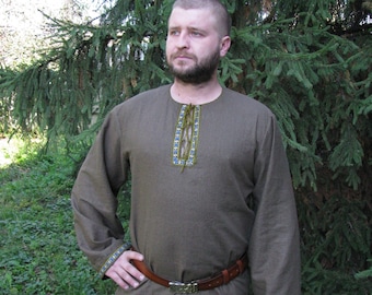 May include: A brown long-sleeved shirt with a decorative neckline and trim. The shirt has a brown leather belt with a metal buckle.