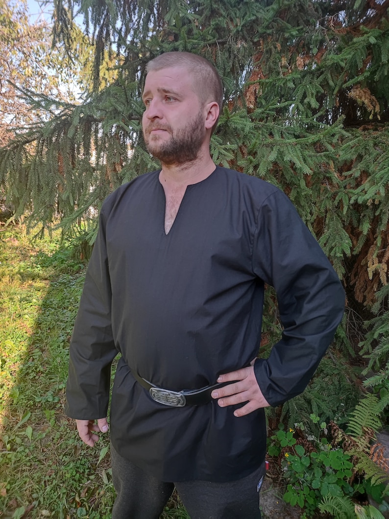 May include: A black long-sleeved shirt with a V-neck and a leather belt. The shirt is made of a soft, comfortable fabric and has a relaxed fit.