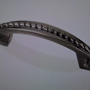 May include: A silver-toned cabinet pull with a rope-like design. The pull has a curved shape and a smooth finish.
