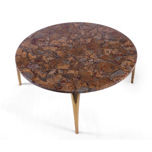 May include: A round, brown and gold coffee table with a marbled top and four gold legs.