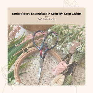 May include: An embroidery kit with the title "Embroidery Essentials: A Step-by-Step Guide" by EAO Craft Studio. The image features embroidery scissors, embroidery floss, and a wooden embroidery hoop. The scissors have a colourful pattern.
