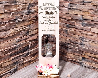 May include: A wooden birthday sign with a heart-shaped planter and a glass lantern. The sign says "Happy Birthday 60 Ulrike 60" and "Zum Geburtstag viel Glück. Erfolg und Gesundheit!"  Wünschen Dir: Anna, Leonie, Marta und Hanna