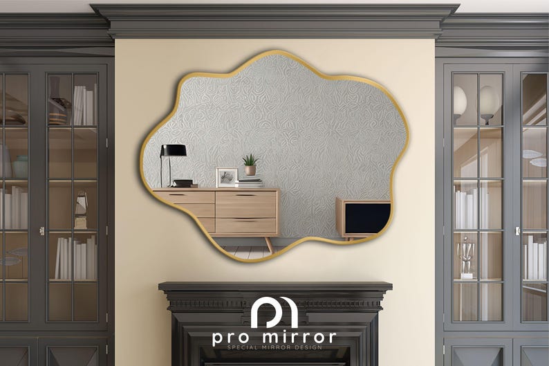 May include: A gold-framed, irregular-shaped mirror with a white, textured surface. The mirror is hanging on a wall with a dark gray cabinet on either side. The mirror reflects a wooden dresser with drawers and a television.