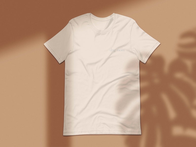 May include: A white t-shirt with the text "dog mom" printed on the front.