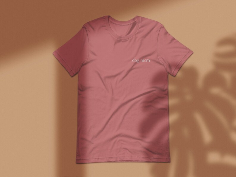 May include: A pink t-shirt with the text "dog mom" printed on the front.