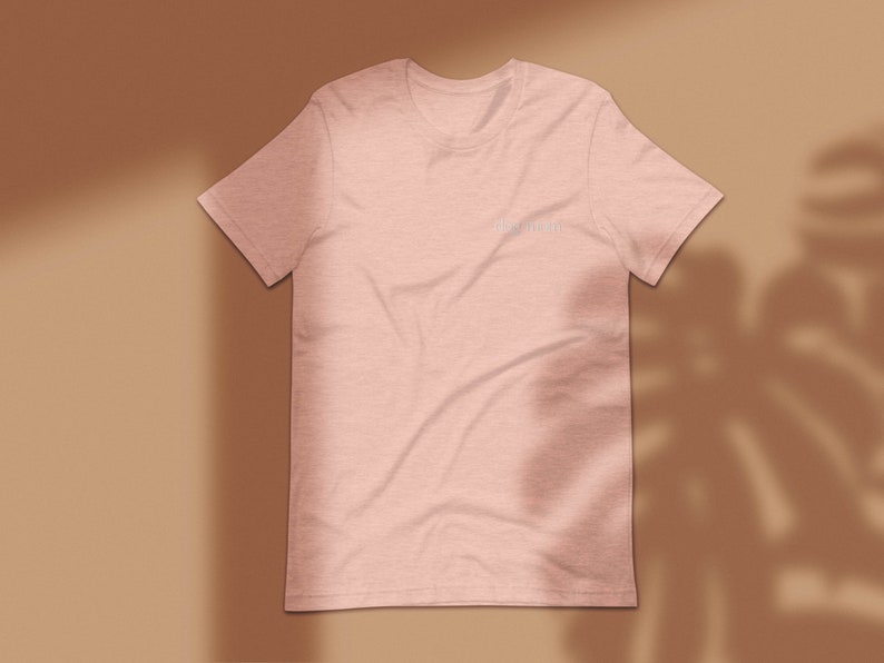 May include: A light pink t-shirt with the text "dream big" printed on the front in a white font.