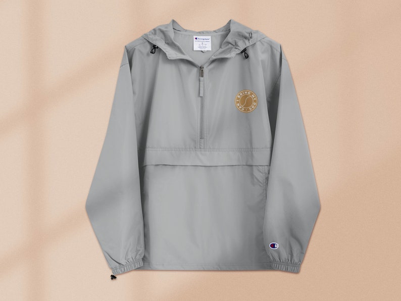 May include: A gray hooded windbreaker with a zipper closure and a small embroidered logo on the left chest that says "Bring My A-Game".