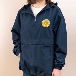 May include: A navy blue hooded jacket with a zipper closure and a gold embroidered patch that says "I can bring my dog".
