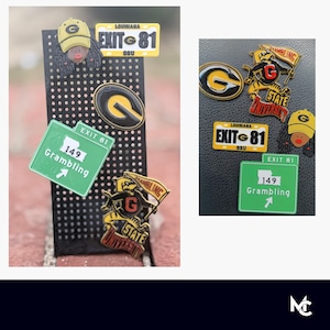 May include: A collection of pins and accessories featuring a black and gold color scheme. The pins include a Louisiana license plate design, a Grambling State University logo, and a road sign that reads "Exit 81" and "Grambling 149".