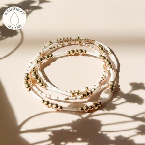 Könnte beinhalten: Handgefertigtes Holzschild mit dem Text "Welcome to our home" in handschriftlichem Stil. Das Schild ist weiß mit schwarzer Schrift bemalt und hat ein verwittertes Finish, ideal für die Inneneinrichtung.