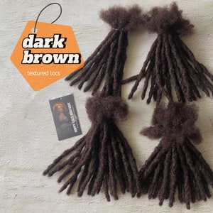 May include: Four bundles of dark brown textured dreadlocks. The dreadlocks are about 18 inches long and have a natural, slightly wavy texture. The dreadlocks are packaged in a clear plastic bag with a white label that says "Happy Locs Boutique".