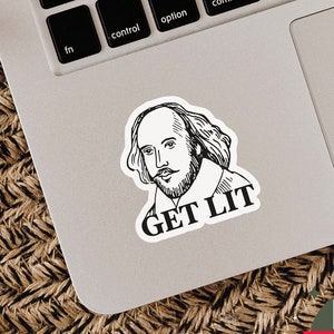 May include: A black and white sticker featuring a portrait of William Shakespeare with the text "GET LIT". The sticker is placed on a laptop. The background is a woven surface.