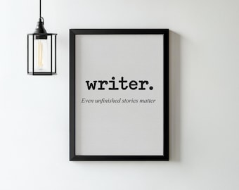May include: A black framed wall art print featuring a white background with the word writer. in a bold serif font, followed by the text Even unfinished stories matter in a smaller, italicised serif font centred below it.