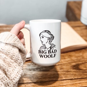May include: White ceramic mug with a black and white illustration of a woman and the text "BIG BAD WOOLF".