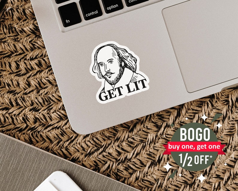 May include: A black and white sticker featuring a portrait of William Shakespeare with the text "GET LIT". The sticker is placed on a laptop. The background is a woven surface.