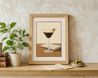 May include: A framed art print shows a martini with an olive, set against a tan backdrop. The print is in a light wood frame and rests on a wooden surface. A small plant and books are to the left, and a small bowl of olives is to the right.