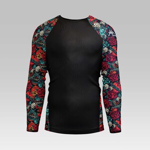 Puede incluir: Camiseta negra de manga larga con cuerpo negro e impresi&oacute;n floral colorida en las mangas. La impresi&oacute;n presenta flores rojas, rosas, azules y verdes, calaveras y otros dise&ntilde;os.