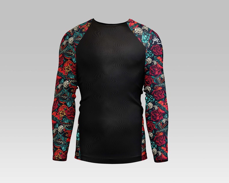 Puede incluir: Camiseta negra de manga larga con cuerpo negro e impresi&oacute;n floral colorida en las mangas. La impresi&oacute;n presenta flores rojas, rosas, azules y verdes, calaveras y otros dise&ntilde;os.